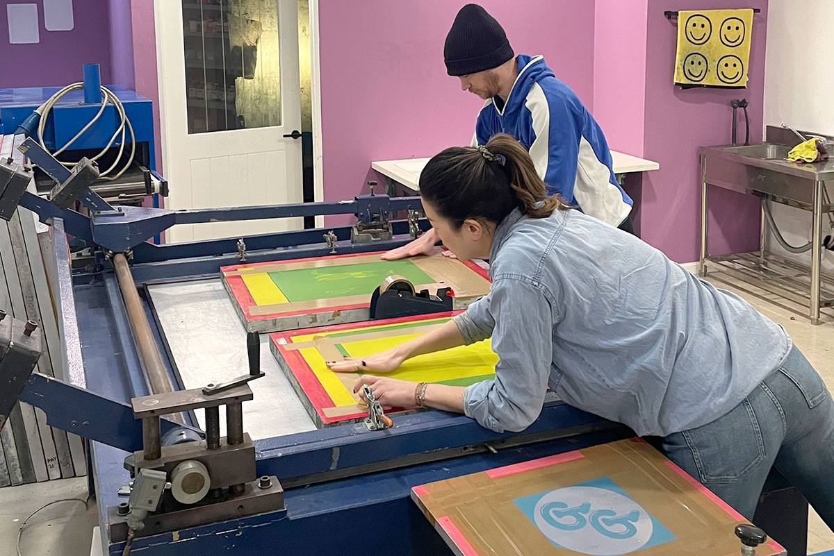 Two printers taping up screens